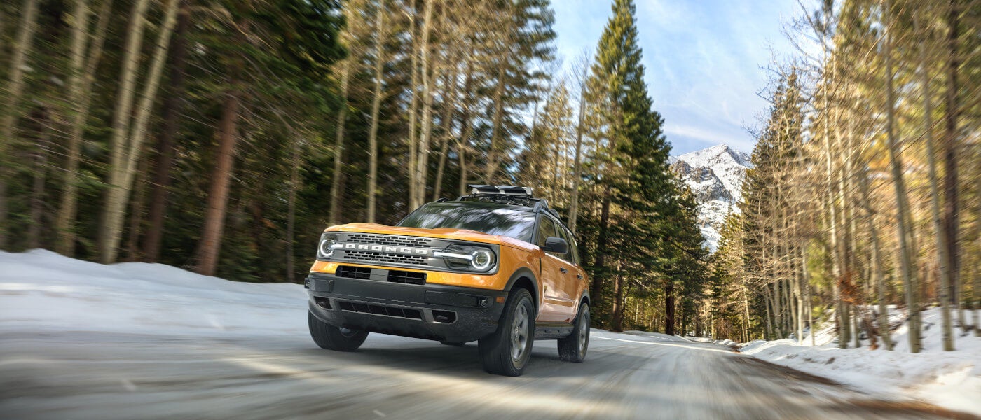 2026 Ford Bronco driving in snowy mountain forest